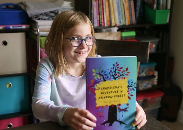 فتاة تحمل كتاباً