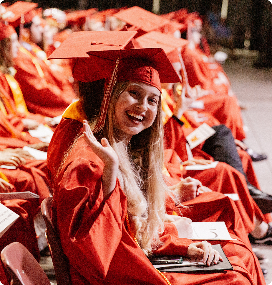 طالبة تلوح للكاميرا في حفل تخرجها